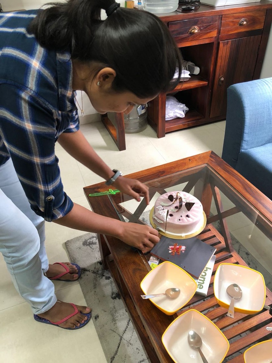 A team member cutting a birthday cake in the office.