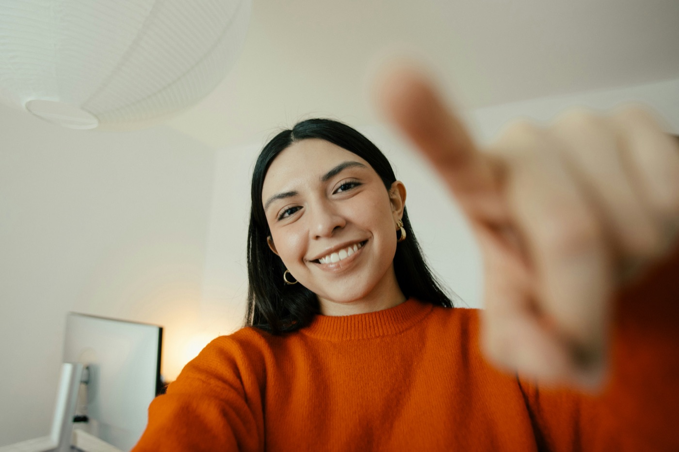 A smiling team member at her desk, welcoming the camera.