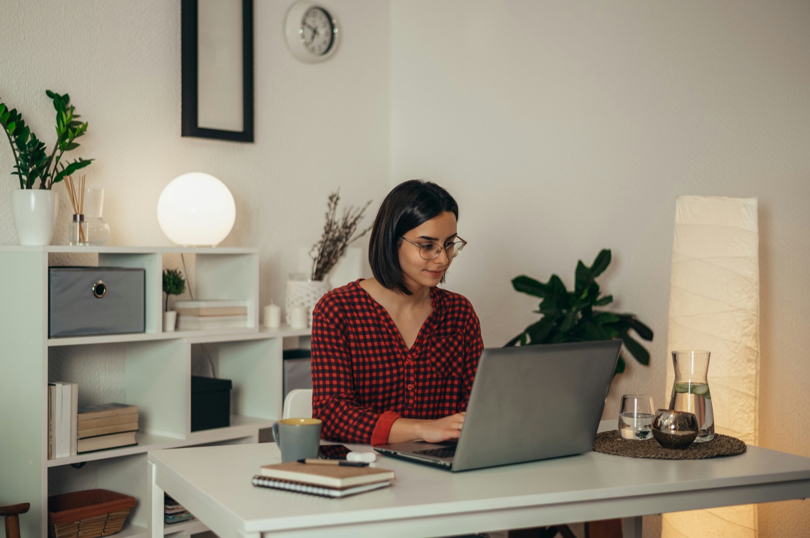A team member working calmly at a laptop in a cosy home office.