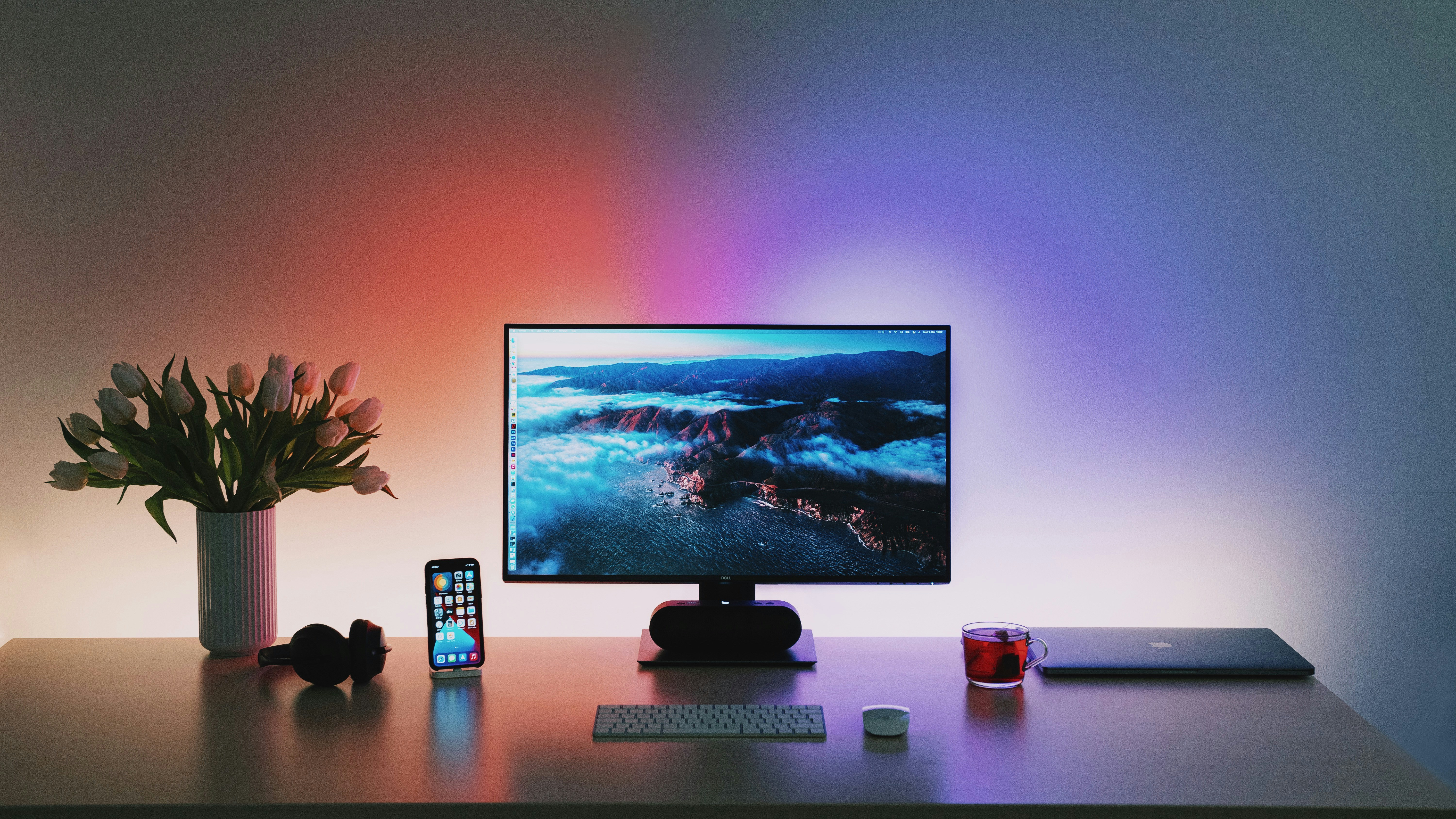A provided desk setup — monitor, laptop, and peripherals lit by an ambient glow.